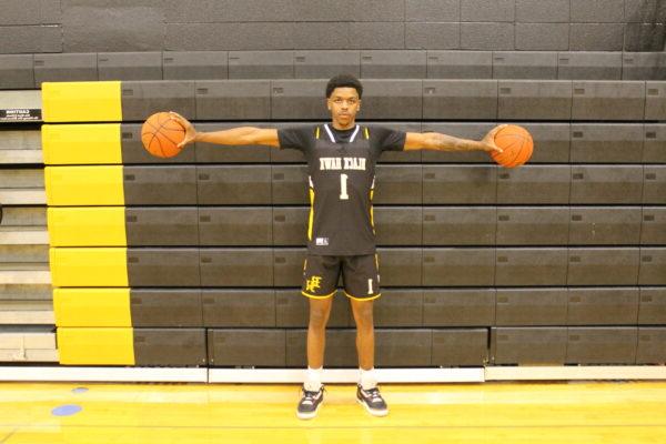 A man holding two basketballs; men's basketball